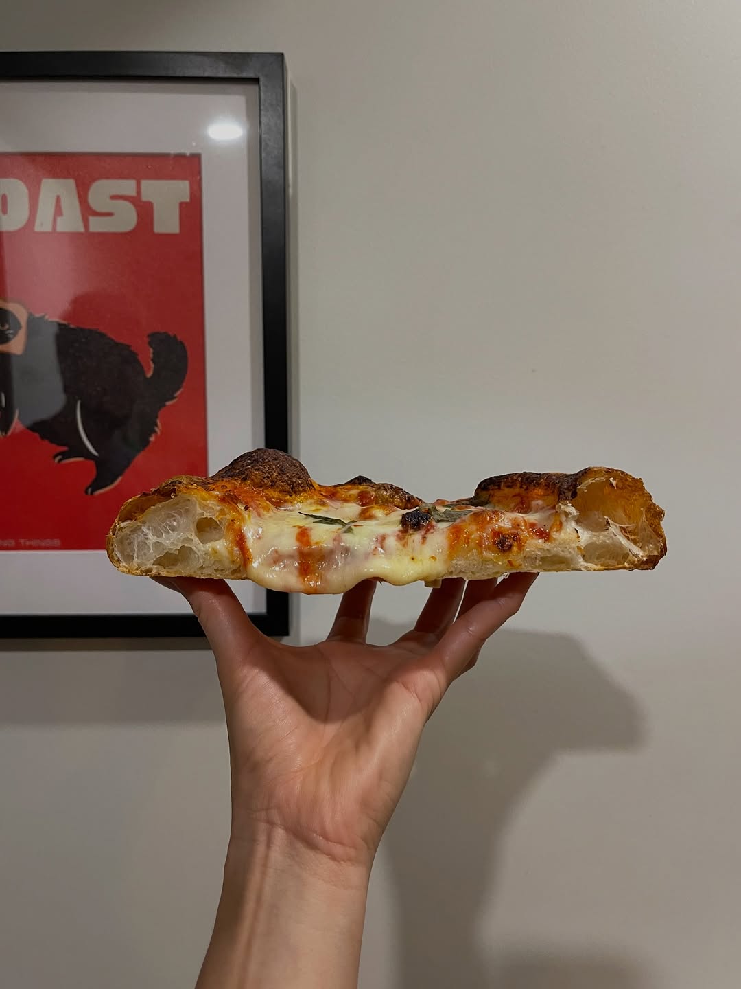 Chef holding a freshly made pizza slice at the Brisbane market stall